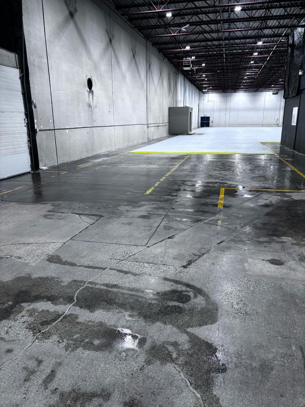 Concrete floor in a large industrial space during a post-construction cleaning project.